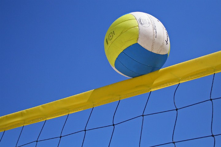 white yellow blue volleyball on top of net