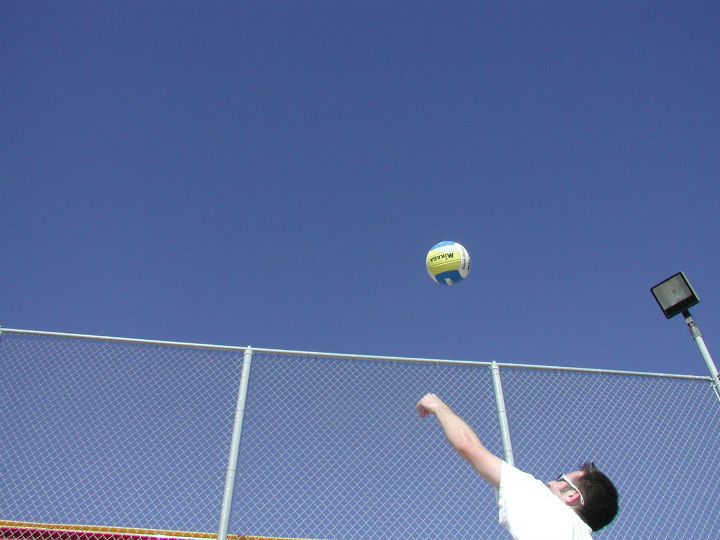 volleyball player tosses ball for serve