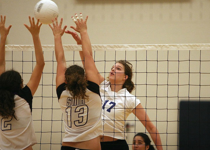 girl playing the ball over the blockers during a volleyball game
