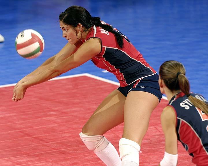 girl bumps volleyball with forearm in game